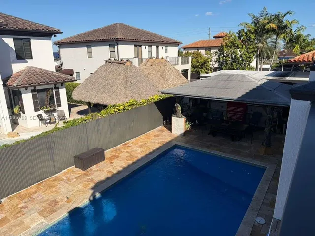 a view of a house with pool and sitting area