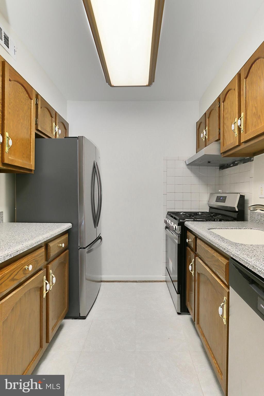 5912 Cove Landing Road, Unit 204 Burke, VA 22015 - Photo 16 of 42 a kitchen with stainless steel appliances granite countertop a sink stove and refrigerator