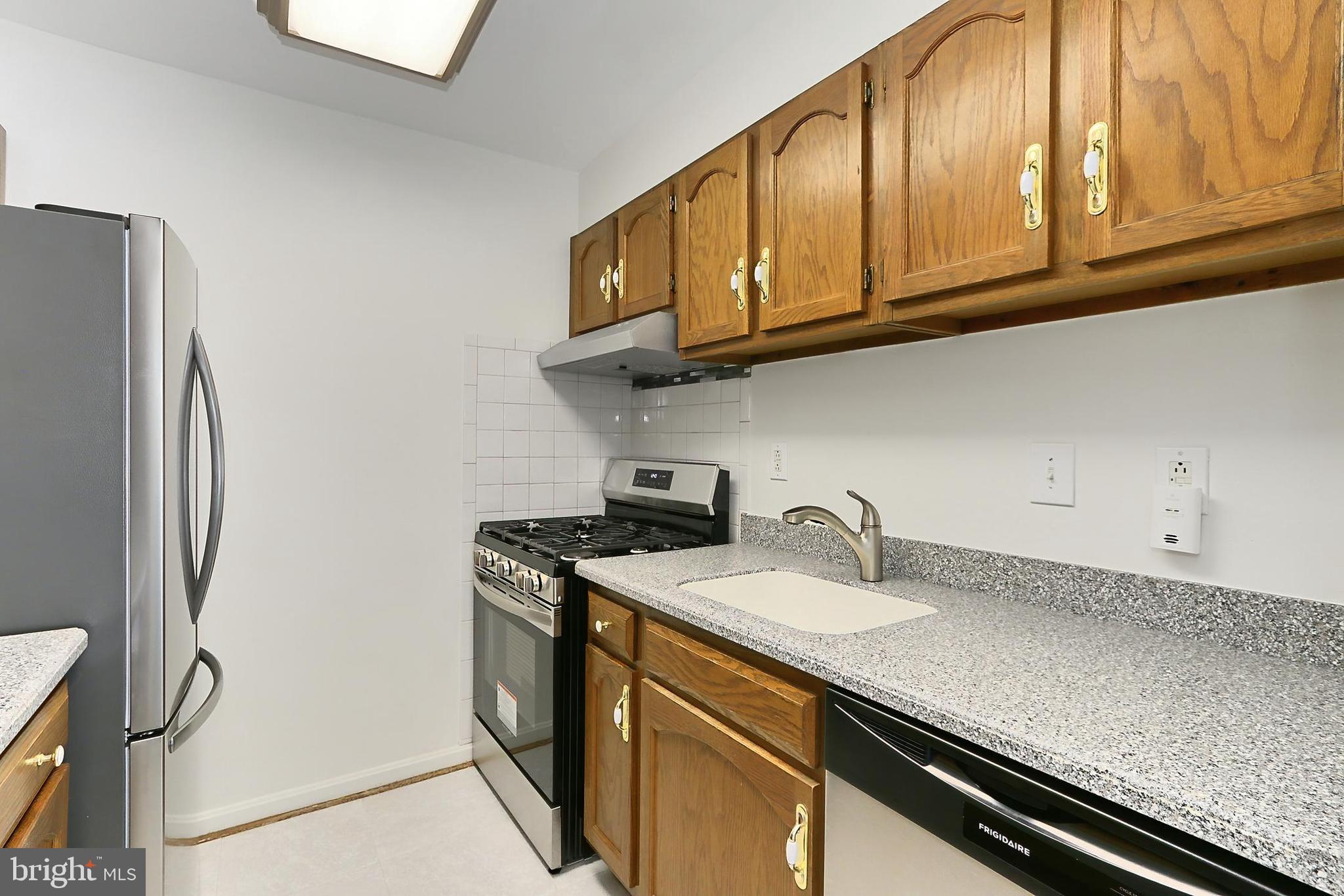 5912 Cove Landing Road, Unit 204 Burke, VA 22015 - Photo 17 of 42 a kitchen with stainless steel appliances granite countertop a sink stove and refrigerator