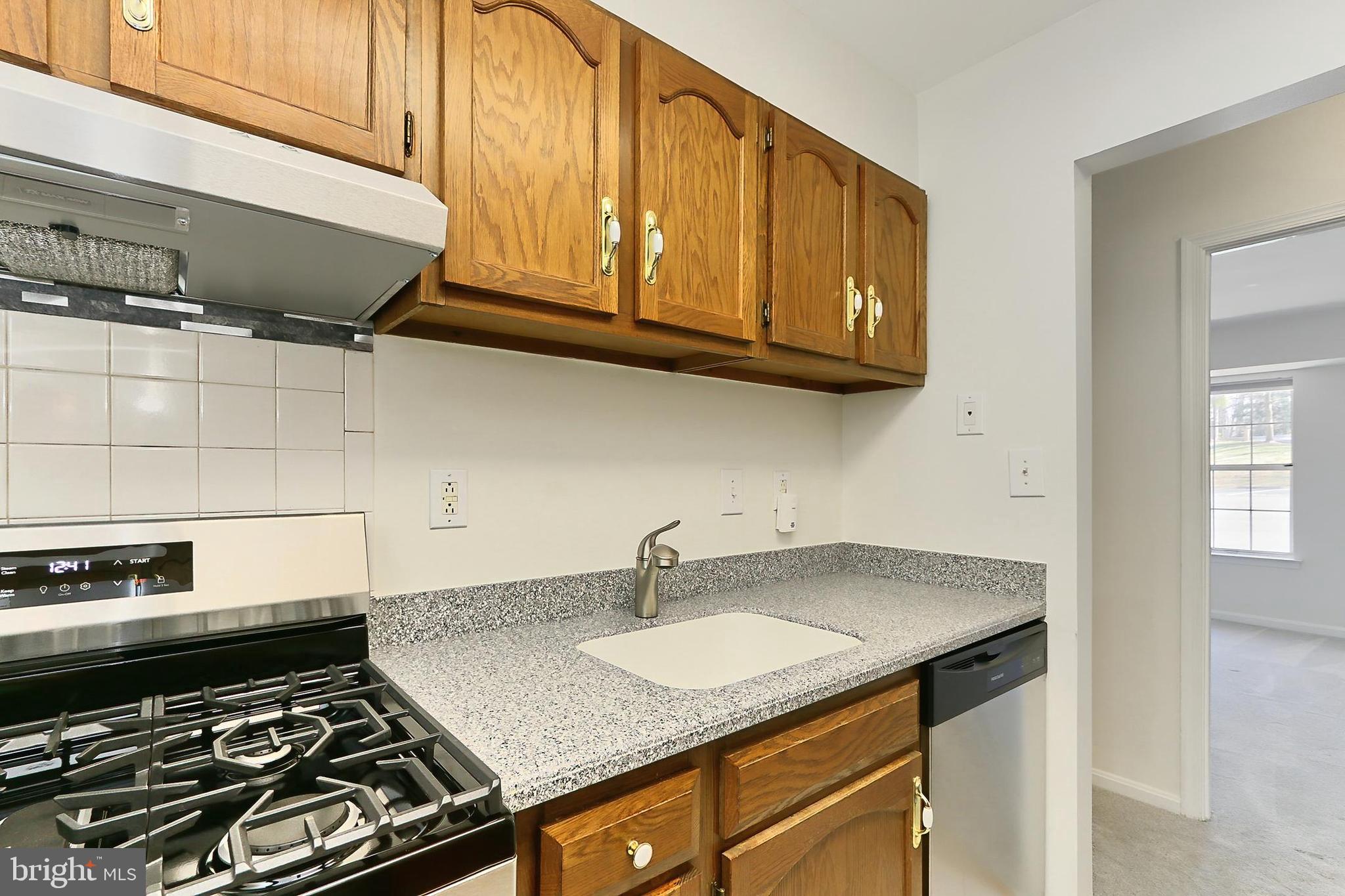 5912 Cove Landing Road, Unit 204 Burke, VA 22015 - Photo 18 of 42 a kitchen with stainless steel appliances granite countertop a sink stove and cabinets