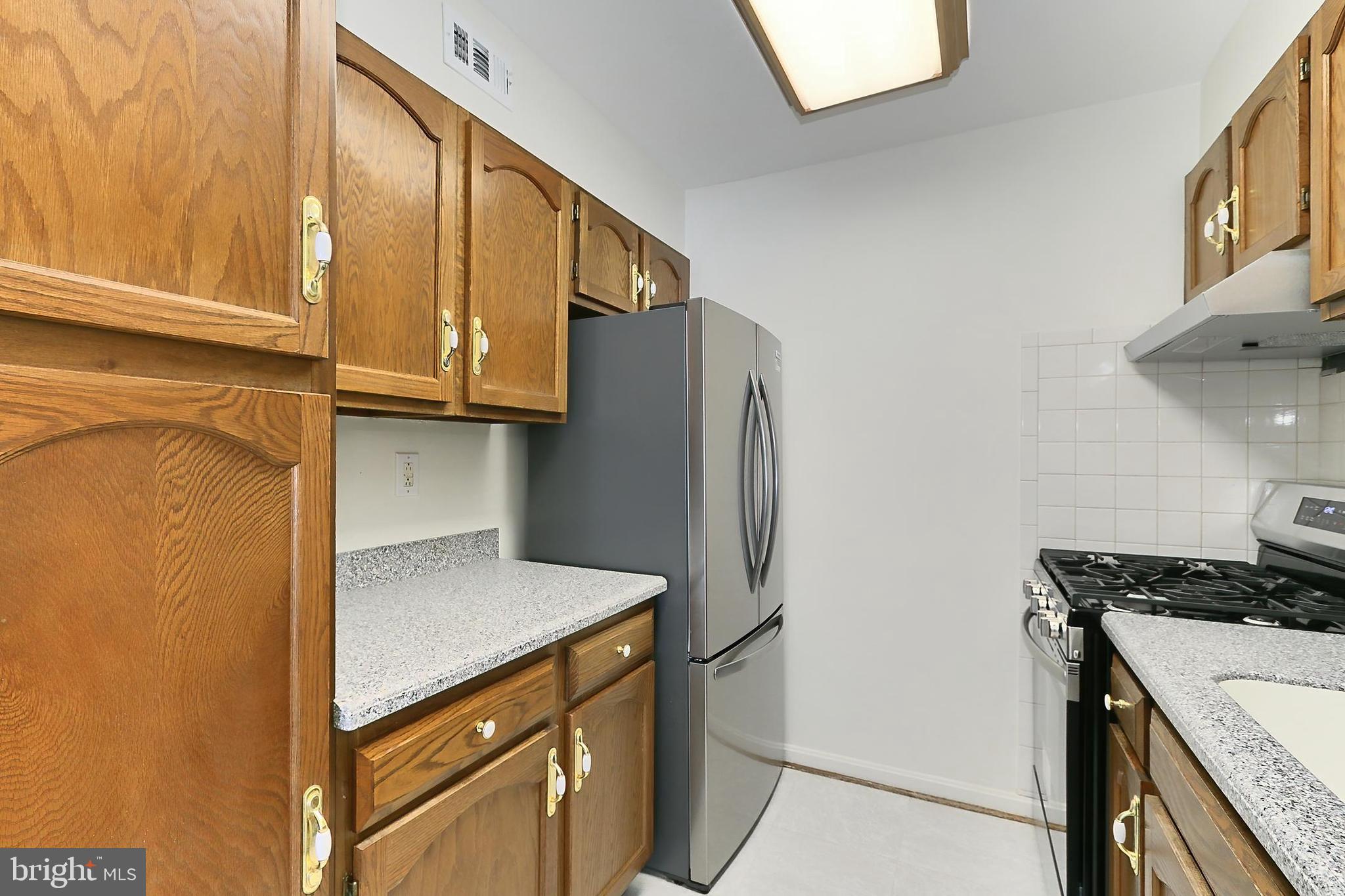 5912 Cove Landing Road, Unit 204 Burke, VA 22015 - Photo 20 of 42 a kitchen with stainless steel appliances granite countertop a refrigerator and a stove