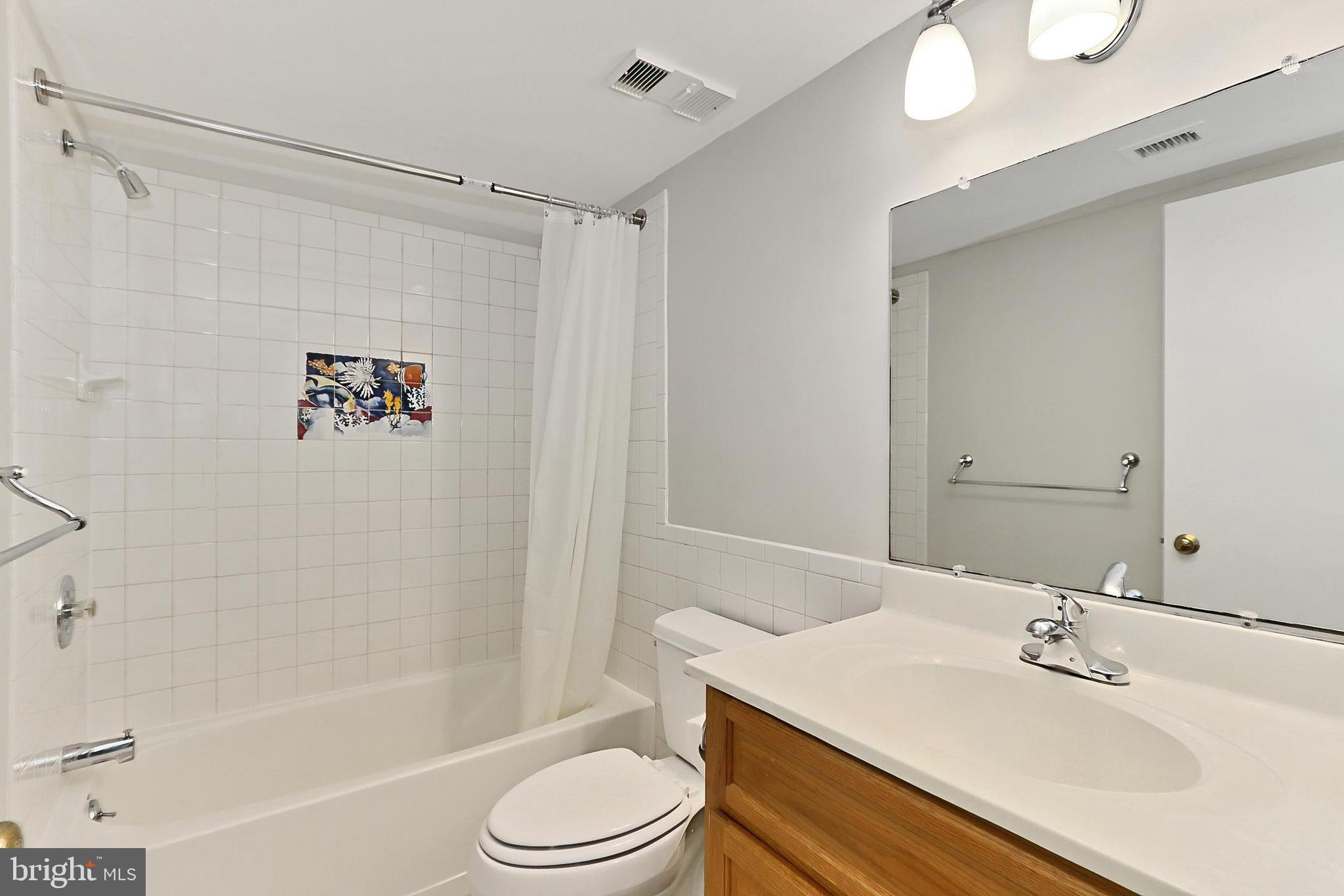 5912 Cove Landing Road, Unit 204 Burke, VA 22015 - Photo 26 of 42 a bathroom with a sink a toilet and shower