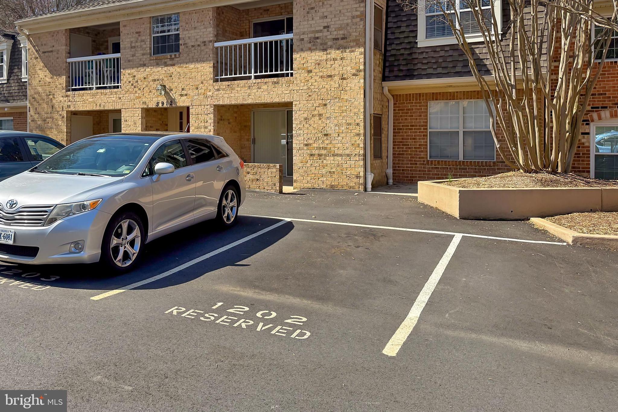 5912 Cove Landing Road, Unit 204 Burke, VA 22015 - Photo 32 of 42 a car parked in front of a brick house with a outdoor space