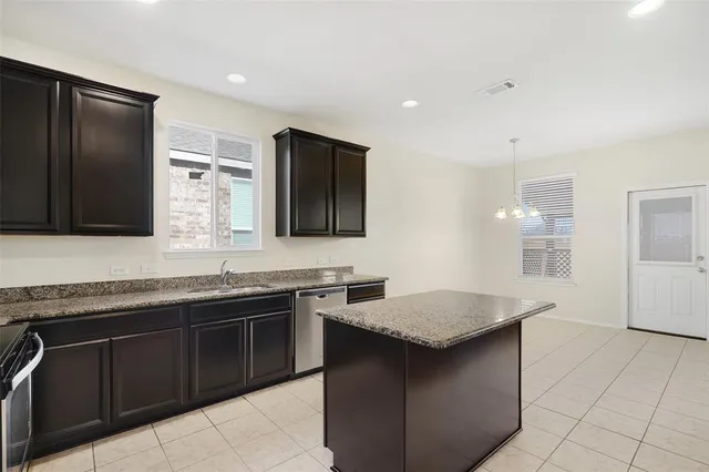 a kitchen with stainless steel appliances granite countertop a sink and a stove