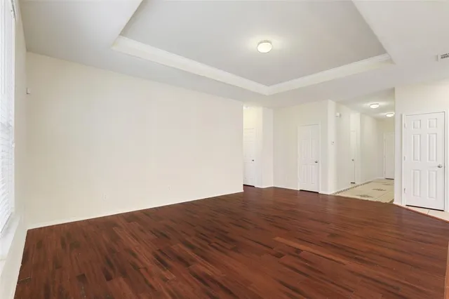 a view of room with wooden floor and white walls