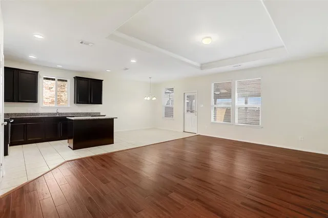 a large white kitchen with wooden floors and stainless steel appliances