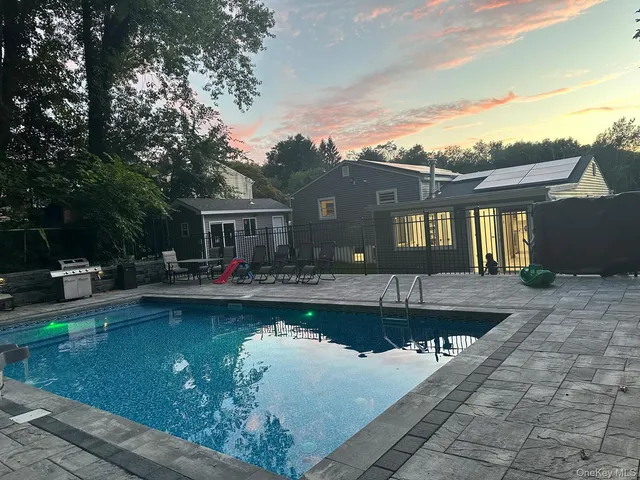 a front view of a house with swimming pool having outdoor seating