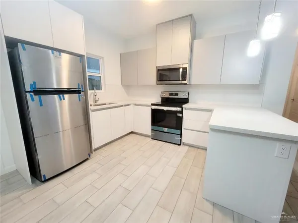 a kitchen with stainless steel appliances a refrigerator sink and microwave