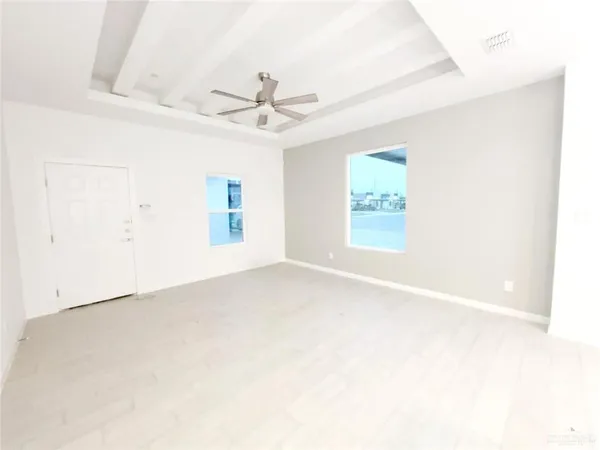 an empty room with windows and fan