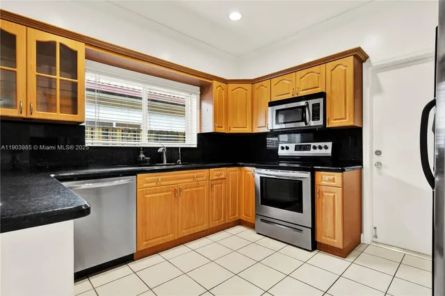a kitchen with granite countertop white cabinets and black appliances