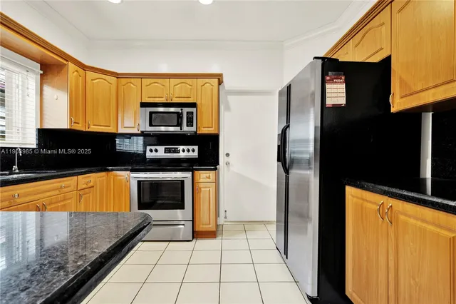 a kitchen with stainless steel appliances granite countertop a refrigerator and a stove