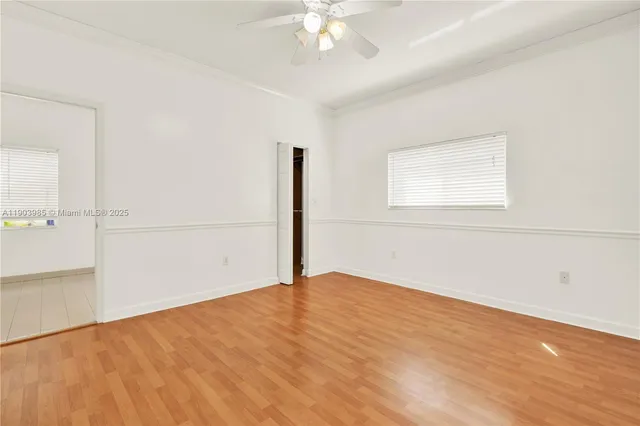 an empty room with wooden floor and closet