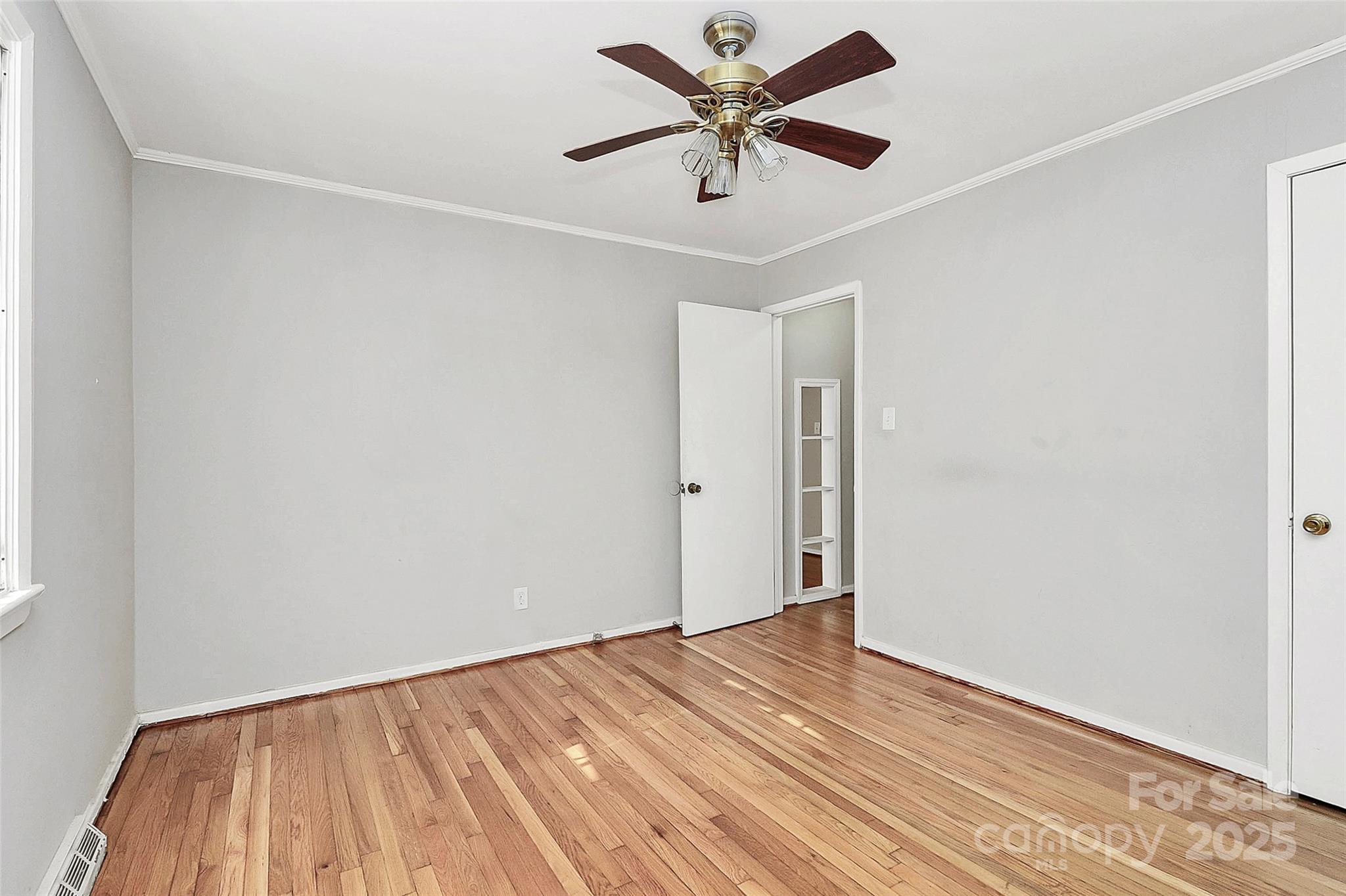 3210 Minnesota Road Charlotte, NC 28208 - Photo 17 of 20 an empty room with a ceiling fan and wooden floor