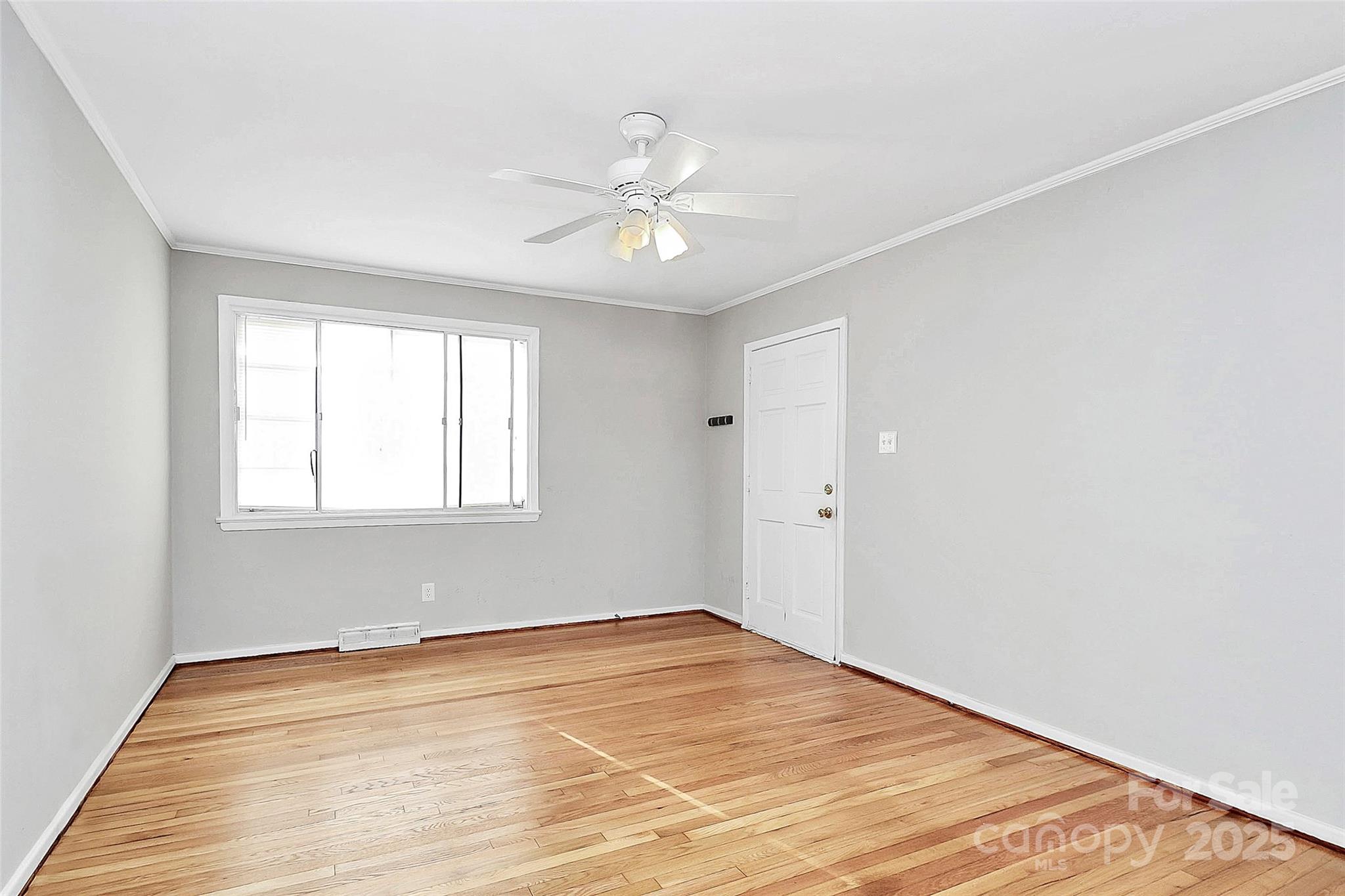 3210 Minnesota Road Charlotte, NC 28208 - Photo 10 of 20 an empty room with wooden floor fan and windows