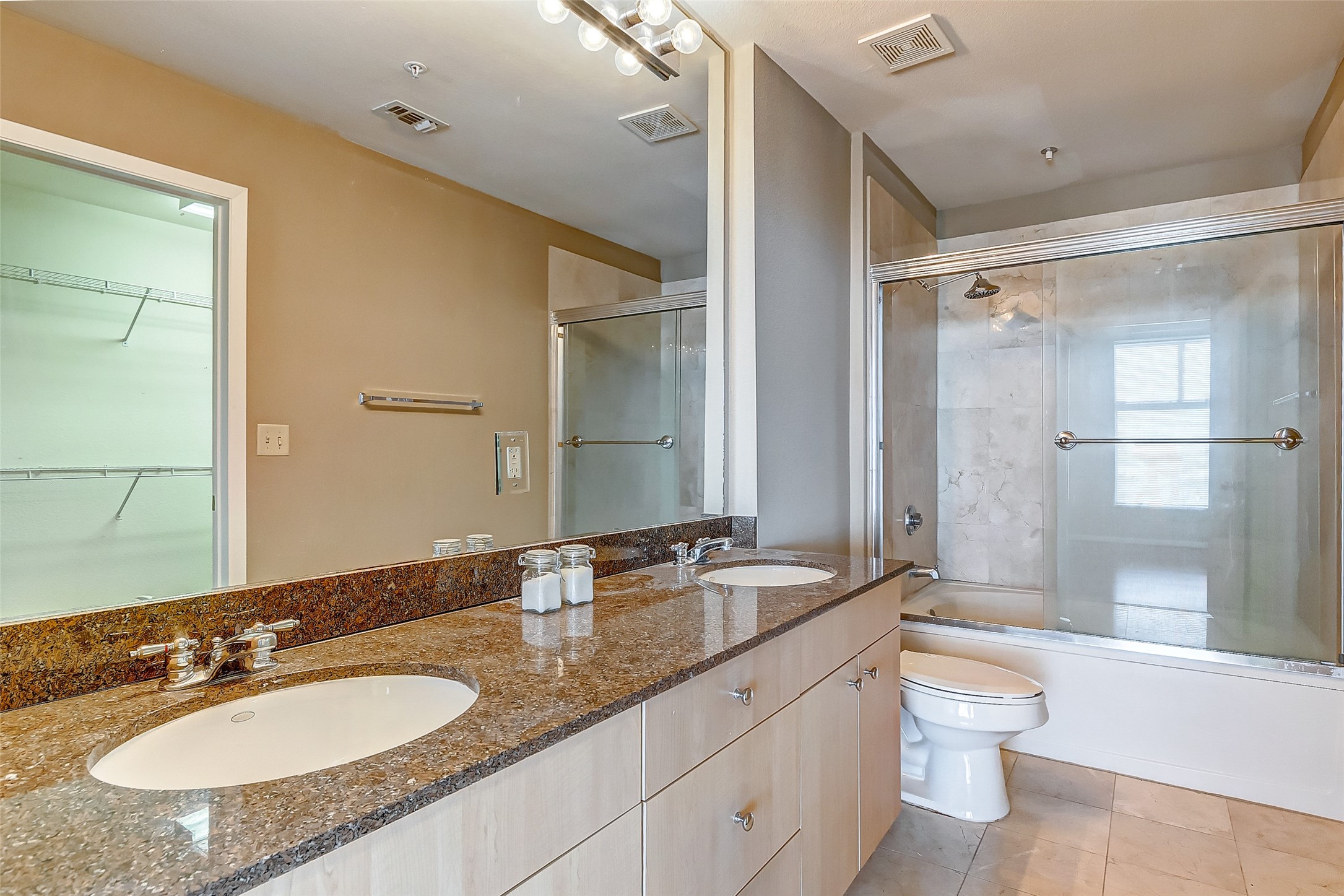 3505 Sage Road, Unit 1702 Houston, TX 77056 - Photo 12 of 23 a bathroom with a granite countertop double vanity sink a mirror and a shower