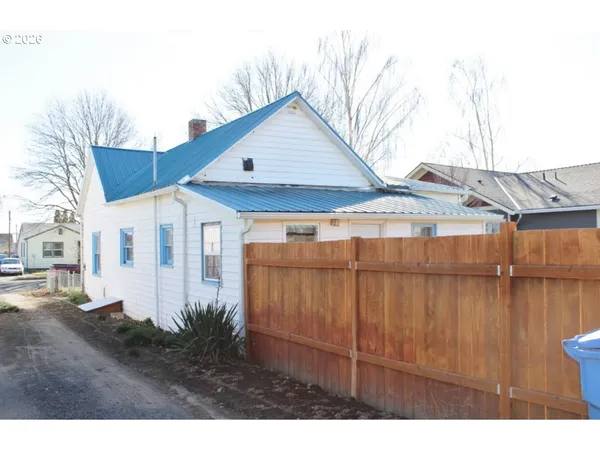 a view of a house with wooden fence