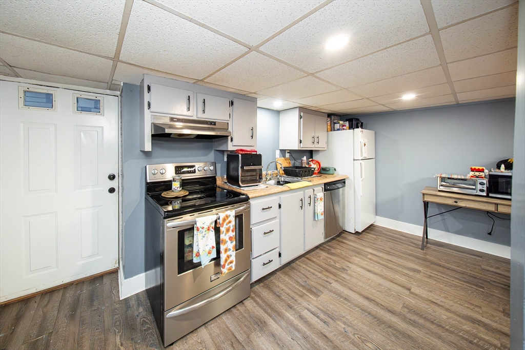 166 Bradford Avenue Fall River, MA 02721 - Photo 19 of 42 a kitchen with stainless steel appliances a stove a sink dishwasher a refrigerator and a dining table with wooden floor