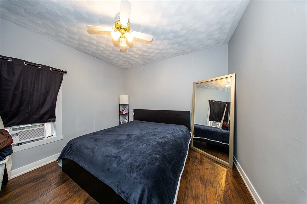 166 Bradford Avenue Fall River, MA 02721 - Photo 30 of 42 a bedroom with a bed and a chandelier