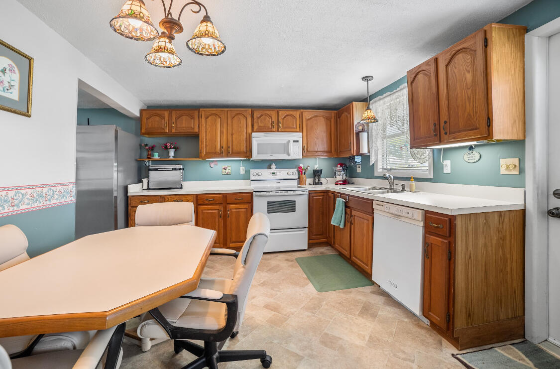 3966 Northwest 20th Avenue Okeechobee, FL 34972 - Photo 3 of 35 a kitchen with a stove a table and chairs