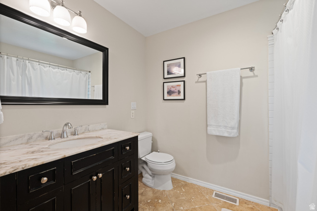 3320 Cherokee Lane Provo, UT 84604 - Photo 23 of 52 Bathroom featuring a dark wood vanity with a light-toned, veined countertop, an undermount sink, and a framed mirror