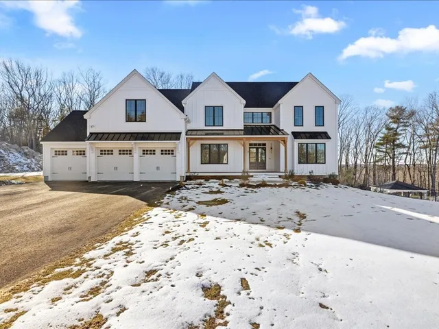 a view of a large white house with a yard covered with snow on the road