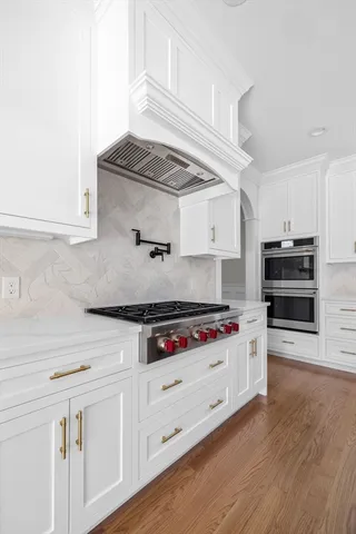 a kitchen with stainless steel appliances a stove and wooden floor