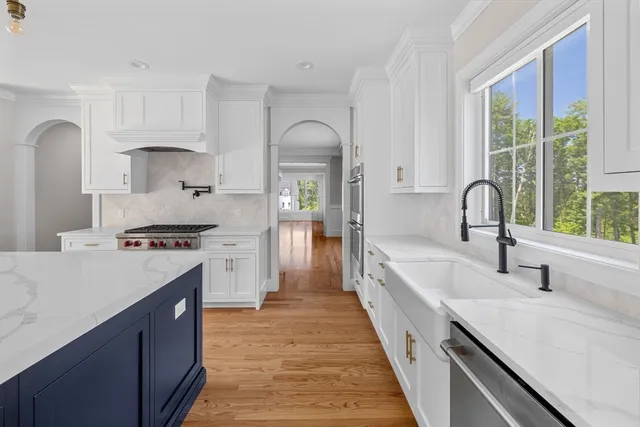 a kitchen with kitchen island granite countertop a sink appliances and cabinets
