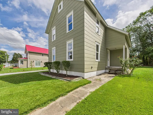 a view of a house with a yard and sitting area