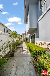 a front view of a house with a yard and potted plants