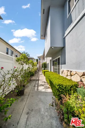 a front view of a house with a yard and potted plants
