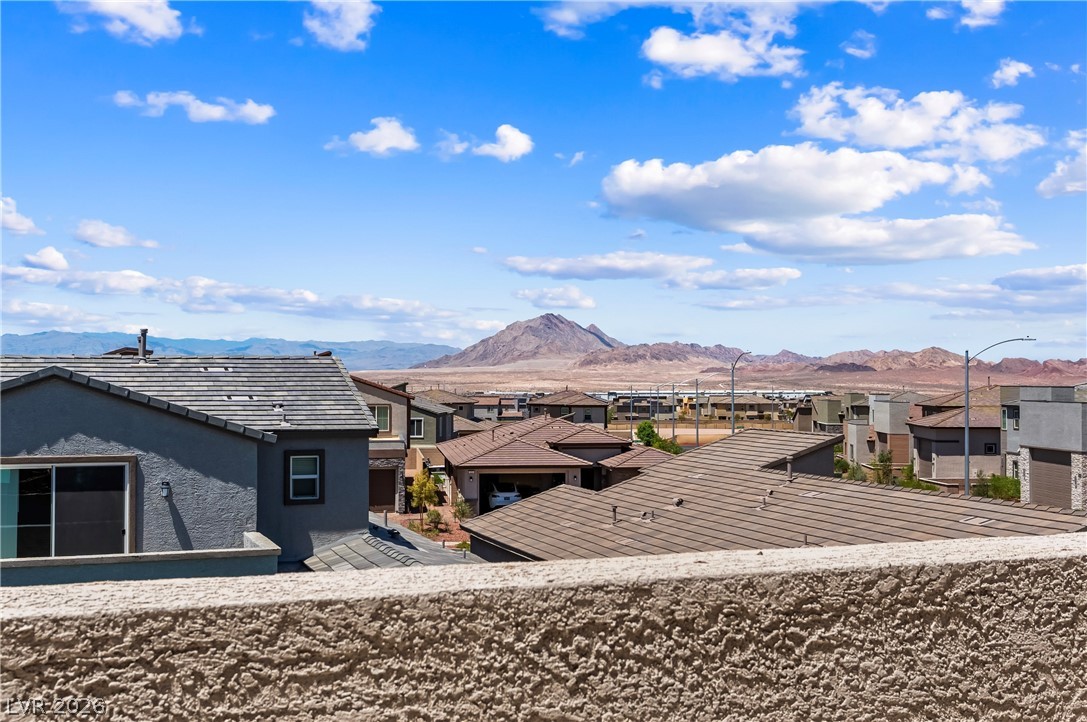 320 Isla Enclave Way Henderson, NV 89011 - Photo 27 of 49 This elevated view captures residential roofs against a vast desert landscape and distant mountains.