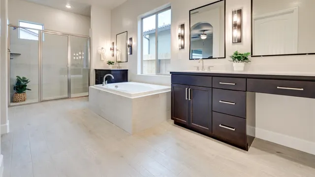 a spacious bathroom with a tub sink and mirror