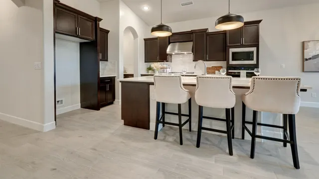 a kitchen with stainless steel appliances kitchen island granite countertop a table and chairs in it