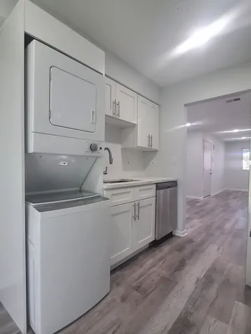 a kitchen with white cabinets and sink
