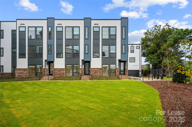 a kitchen with stainless steel appliances granite countertop a sink a stove and chairs