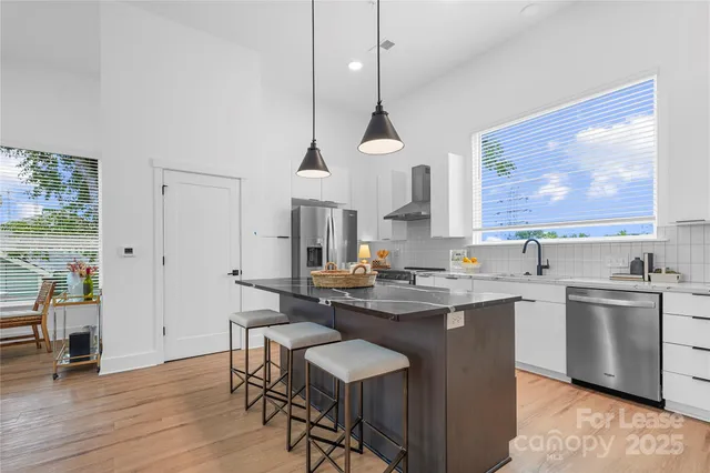 a kitchen with a sink cabinets stainless steel appliances and a window