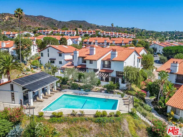 an aerial view of a house with a garden and lake view
