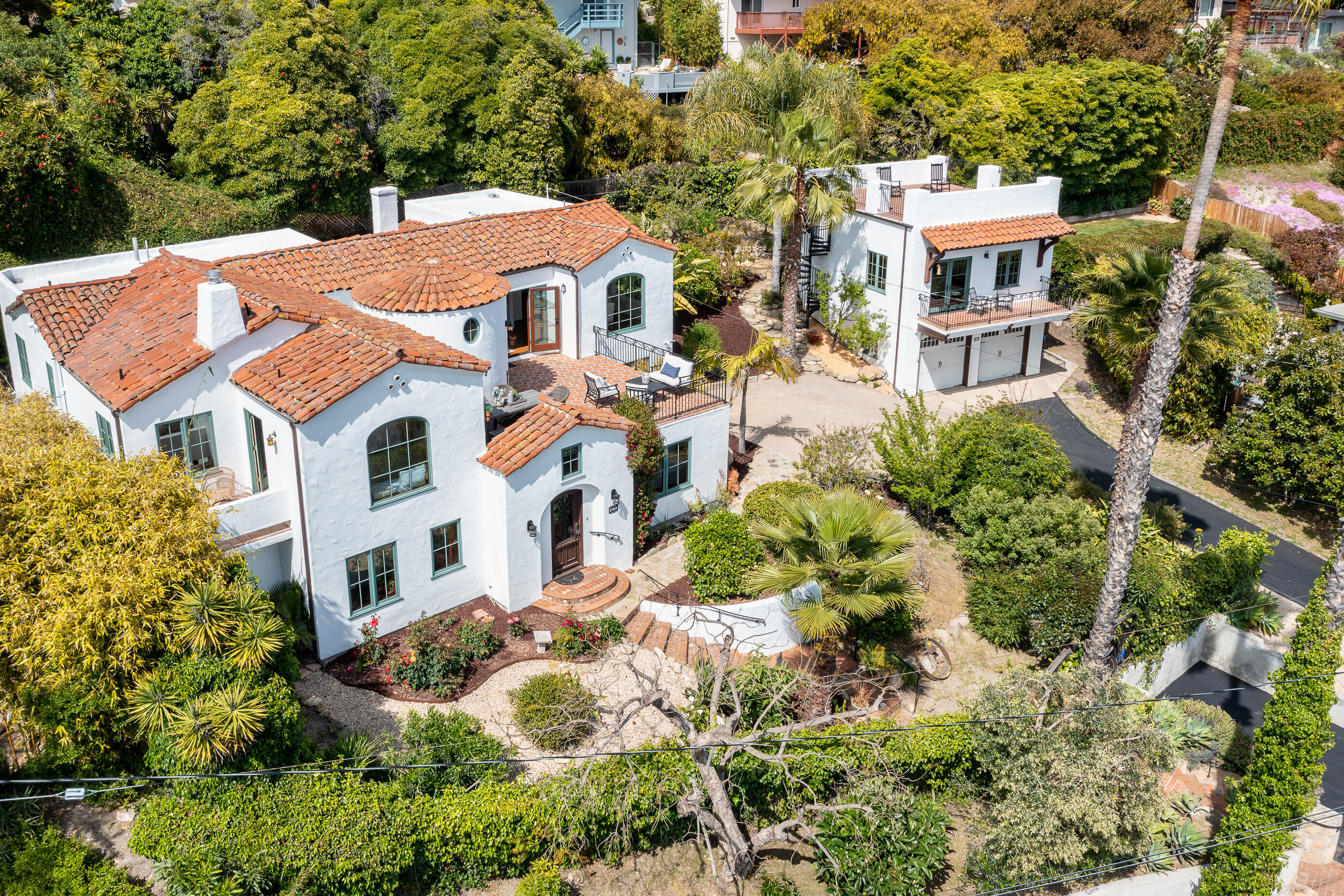a aerial view of a multi story residential apartment building with a yard and large trees