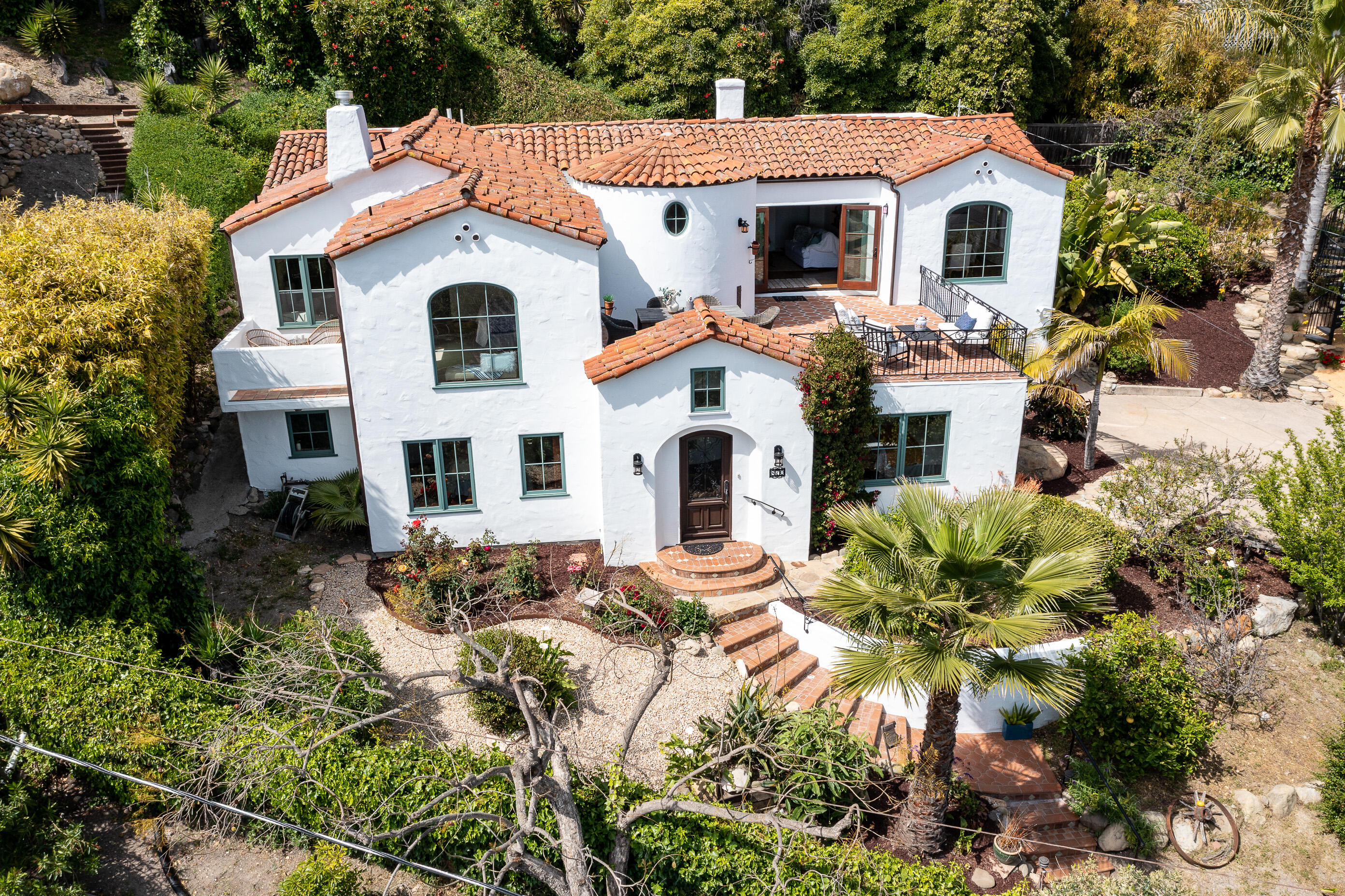 870 Windsor Way Santa Barbara, CA 93105 - Photo 22 of 59 a view of a white house with large windows and flower plants