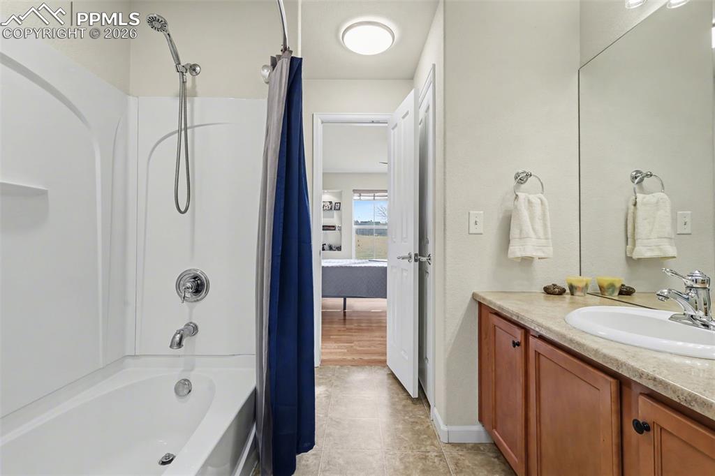 17063 Blue Mist Grove Monument, CO 80132 - Photo 20 of 33 a bathroom with a granite countertop sink a mirror and a bathtub