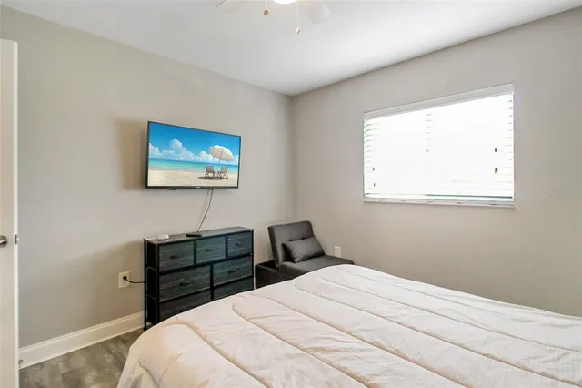 a bedroom with a bed a wall painting and window