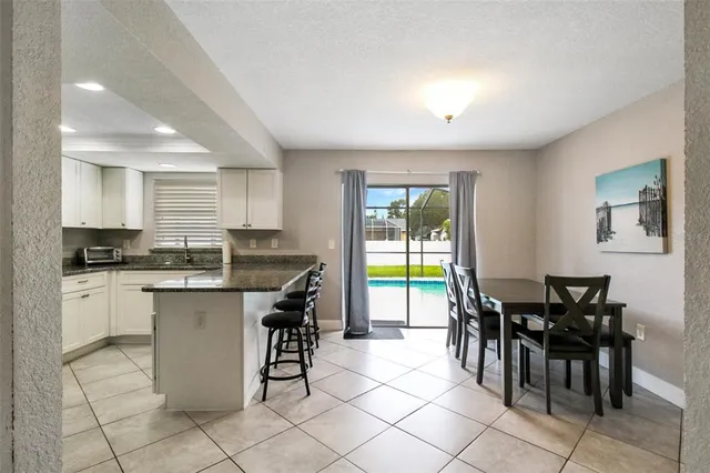 a kitchen with a sink and chairs