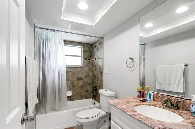 a bathroom with a granite countertop sink toilet a mirror and shower