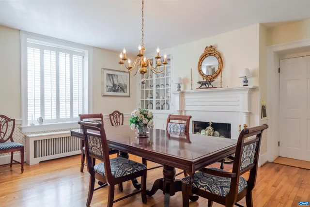 a dining room with furniture a chandelier and wooden floor