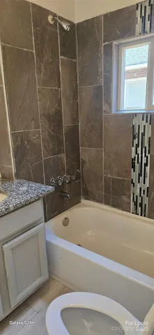 a white bath tub sitting next to a white toilet