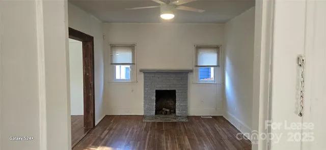 a view of a livingroom with wooden floor and a fireplace