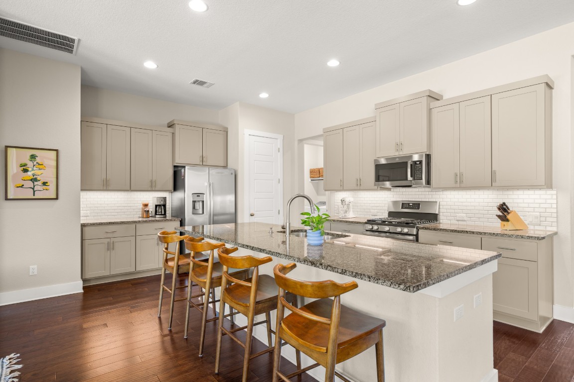 a kitchen with appliances a sink and cabinets