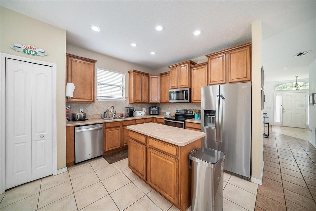 12045 Colony Lakes Boulevard New Port Richey, FL 34654 - Photo 4 of 22 a kitchen with stainless steel appliances granite countertop a refrigerator a sink dishwasher a stove top oven a refrigerator and white cabinets