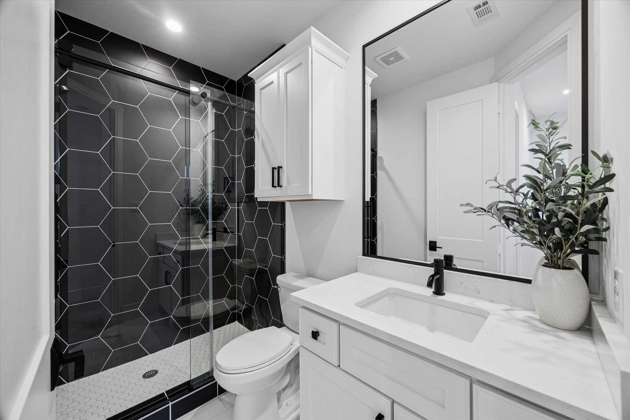 1661 Bingle Road Houston, TX 77055 - Photo 28 of 33 shared 2nd level bathroom. hexagon tiles, quartz countertops. matte black accents.