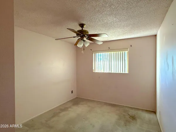 an empty room with a window and a ceiling fan
